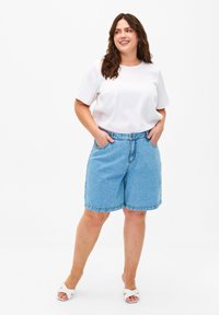 Shorts in denim blu chiaro con una vestibilità comoda, vita elastica e tasche laterali, abbinati a una maglietta bianca a maniche corte in costina.