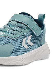 Jasnoniebieskie buty sportowe z przewiewną siateczką na wierzchu, białymi akcentami i paskiem na rzep. Posiadają teksturowaną podeszwę oraz wyściełany kołnierz dla komfortu.