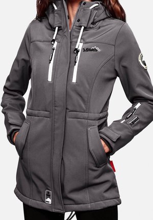 Femme portant une veste softshell grise avec des poches zippées devant et aux manches, capuche réglable et logos de marque sur la poitrine et le bras.