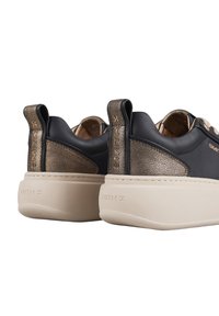 Sneaker neri con dettagli metallici in bronzo, in morbida pelle e soletta beige testurizzata. Presentano un pull tab e un marchio distintivo.