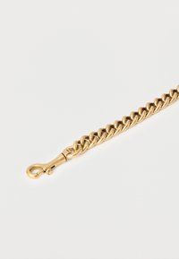 Βραχιόλι από χρυσή αλυσίδα με διαπλεκόμενους κρίκους και κούμπωμα με κρίκο καβουριού σε λευκό φόντο.