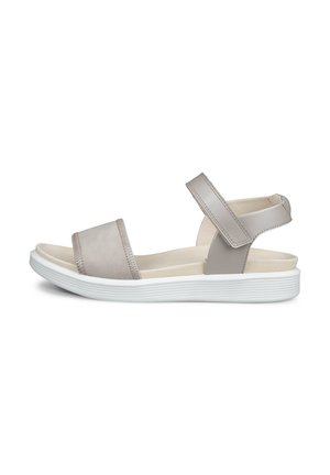 Beige open-toe sandal with adjustable ankle strap and white cushioned sole designed for casual wear.