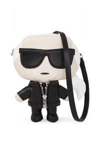 Svart-hvitt plysjhåndveske i form av en tegneseriefigur, med glidelåsjakke, svarte solbriller og avtakbar skulderstropp.
