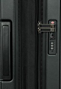 Schwarzer Koffer mit strukturiertem Oberflächen, doppelten Reißverschlüssen und einem Zahlenschloss an der Seite, ausgestattet mit einer matten Oberfläche und einem stabilen Griff.