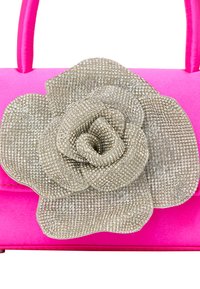 Pink håndtaske med en tekstureret overflade, prydet med en stor metallisk sølvblomst accentueret med rhinsten. Håndtagene er også pink.
