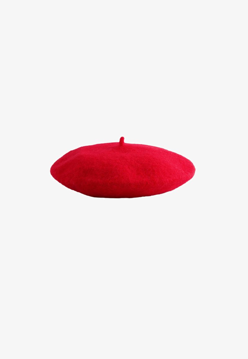 Béret en laine rouge avec une petite tige sur le dessus, plat et rond, isolé sur fond blanc.