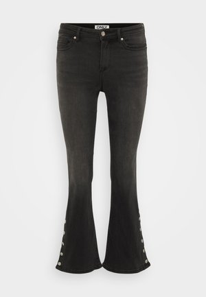 Sorte flagrende jeans laget av denim, med metalliske knappdetaljer på den nedre siden og klassisk fem-lommers design.