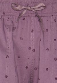 Purple shorts with an elastic waistband and drawstring, featuring small patterned logos and dots throughout. Soft texture and lightweight material.