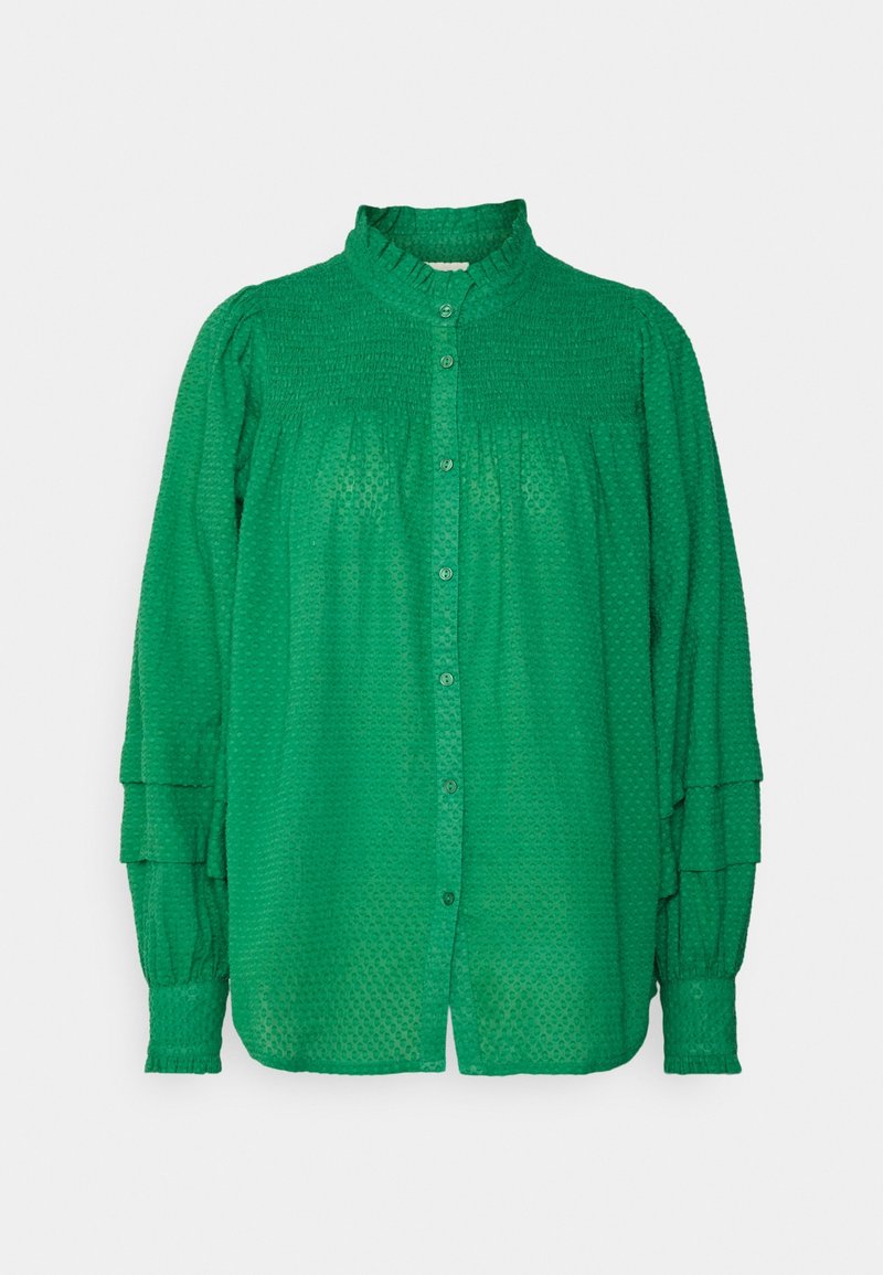 Blouse verte à manches longues en tissu texturé, fermeture boutonnée devant, col montant à volants et manches à volants avec poignets ajustés.