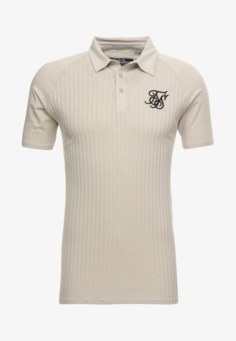 Polo beige présentant une texture côtelée, des manches raglan courtes, un plastron à trois boutons et un logo noir brodé sur la poitrine.