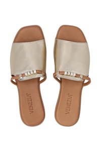 Guld faux læder slide sandaler med en tan fodseng, firkantet tå og dekorativ rem med klare detaljer.