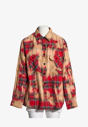 Langærmet skjorte med knapper med rødt og beige batikternet mønster og to forreste brystlommer med knaplukning på en hvid mannequin.