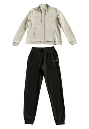 Giacca beige con zip e tasche frontali e pantaloni jogger neri con vita elastica, entrambi con il logo "FREDDY" sul petto e sulla manica.