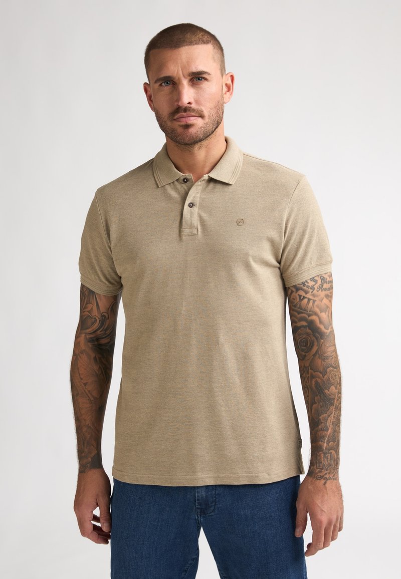 Beige poloshirt met een klassieke kraag, drieknopsoverslag, korte mouwen en een subtiele textuur. Voorzien van een klein logo aan de voorkant.