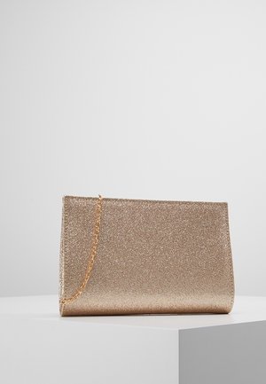 Kultainen kimaltava clutch-laukku, jossa on hoikka suorakulmainen muoto ja hieno kultainen ketjuhihna, lepää valkoisella alustalla.