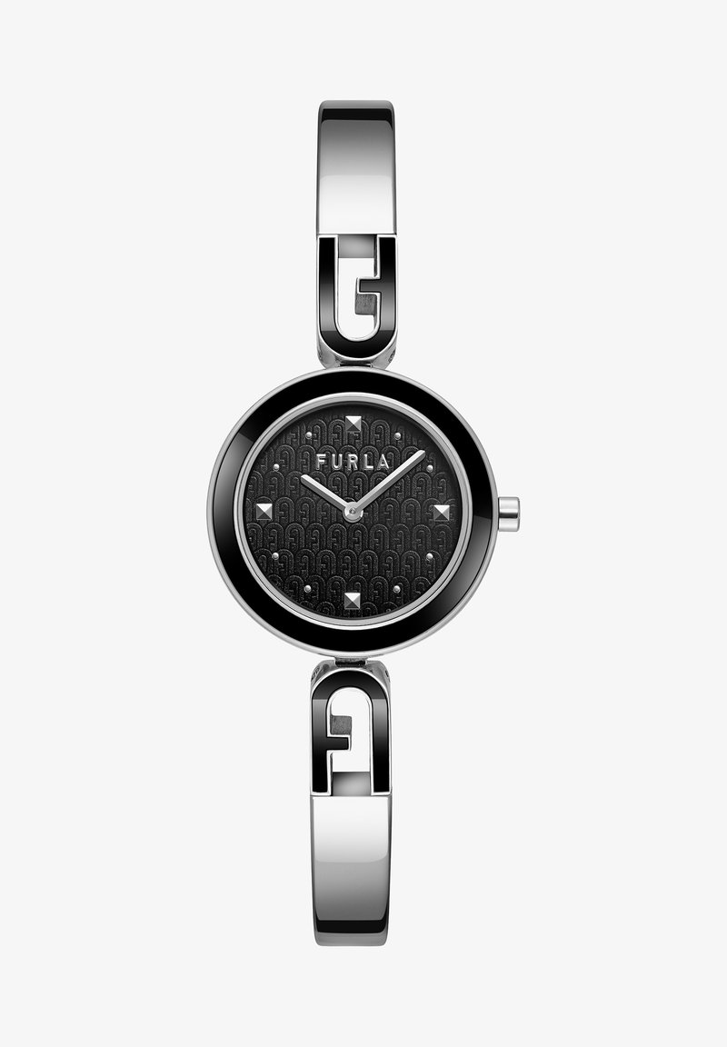 Hõbedane metallkell ovaalse näo, musta tekstuuriga taustaga, millel on logo muster, hõbedased tunni- ja minutinäidud ning dekoratiivsed naelad.