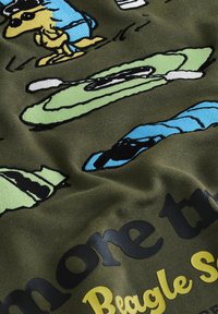 Grafisch sweatshirt van donker groene stof. Het toont kleurrijke geborduurde ontwerpen van een beagle en kajak, met gedurfde tekstaccenten.