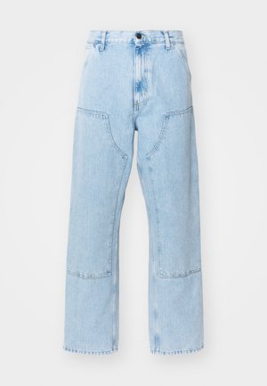 Jean en denim bleu clair, à jambe droite, avec de grandes poches avant et des coutures contrastées. Le tissu a une texture douce et délavée.