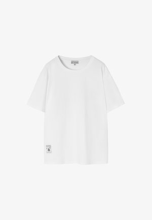 Biała koszulka z krótkim rękawem i okrągłym dekoltem, wykonana z miękkiej bawełny. Posiada małą metkę na dolnej lewej stronie.