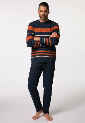 Pasiasty, długosleeve top w granatowym i pomarańczowym kolorze z wąskimi białymi liniami; połączony z granatowymi spodniami z bocznymi kieszeniami i gładką fakturą.