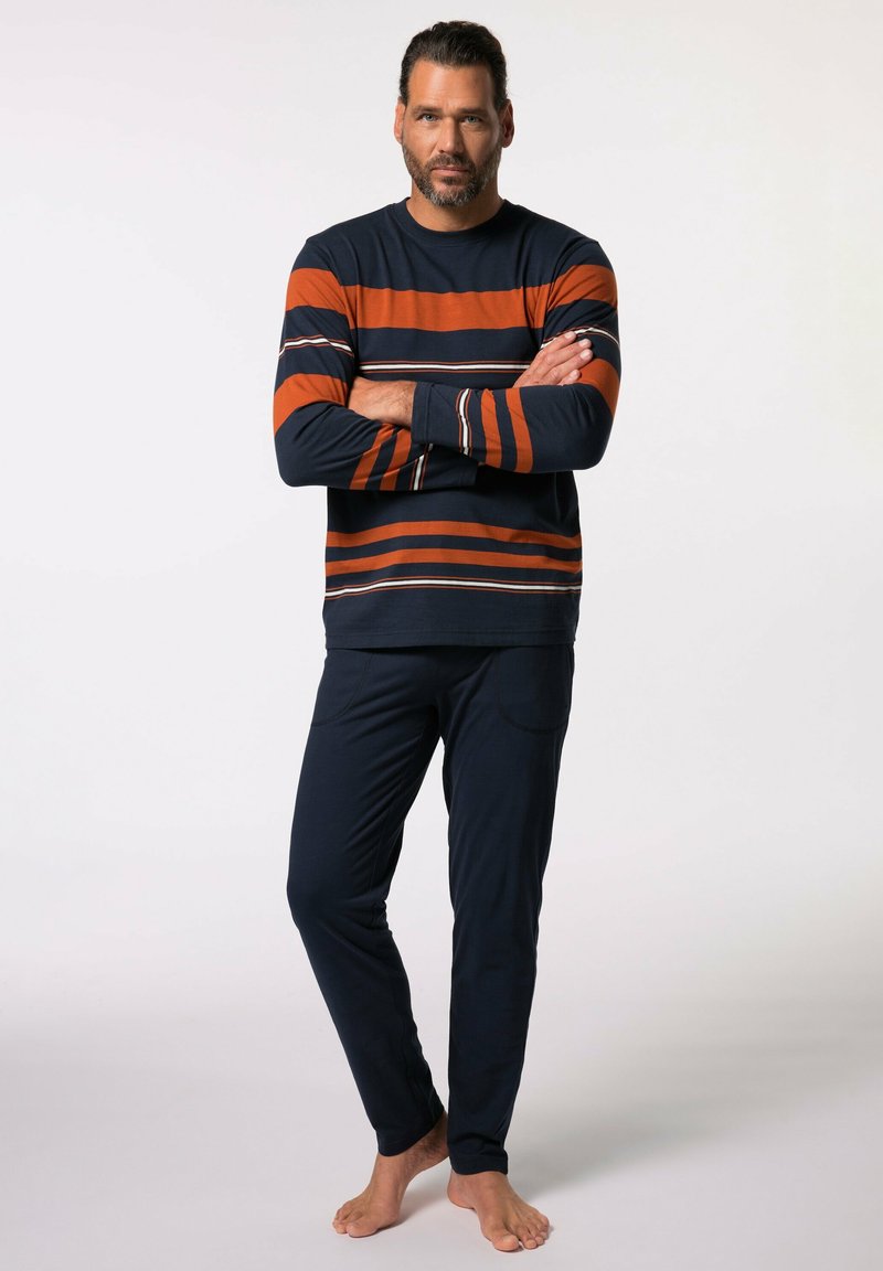 Top de rayas de manga larga en azul marino y naranja con líneas blancas finas; combinado con pantalones azul marino que tienen bolsillos laterales y una textura suave.