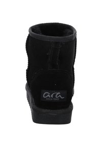Schwarze Wildleder-Ankle-Boots mit runder Form, weicher Innenausstattung, verstärkten Nähten und flacher Gummisohle. Mit einem Logosticker auf der Rückseite.