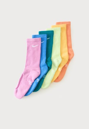 Seks par ribstrikkede ankelsokker i pink, blå, teal, lysegrøn, gul og orange, hver med et hvidt Nike-logo nær toppen.