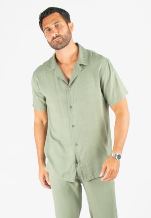 Chemise à boutons à manches courtes vert olive, en tissu léger, coupe décontractée, col plat, poche avant, assortie avec un pantalon similaire.