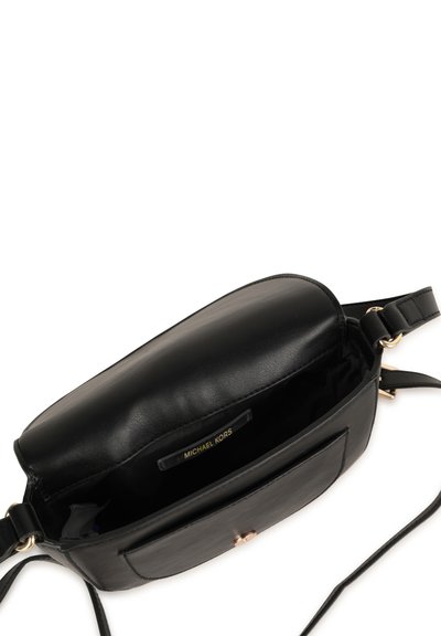 Svart läder crossbody-väska med rundad form, guldfärgade detaljer och en framficka. Inuti finns en märkesetikett.