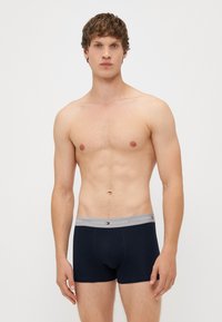 Sötétkék pamut boxer alsó ezüstszínű rugalmas derékkal, rajta a "TOMMY HILFIGER" logóval és emblémával, testhez simuló fazon.