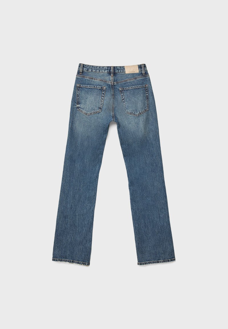 Jeans denim blu a gamba dritta mostrati da dietro con due tasche applicate e una piccola etichetta rettangolare sulla cintura.