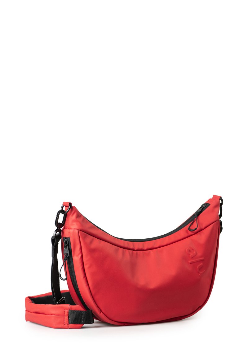 Rote Nylon-Schultertasche mit geschwungenem Design, ausgestattet mit einem schwarzen Reißverschluss, verstellbarem Trageriemen und leicht geprägtem Logo an der Seite.