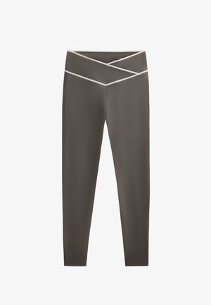 Leggings gris foncé avec une texture lisse, présentant un design de taille crisscross et des accents contrastants en gris clair.