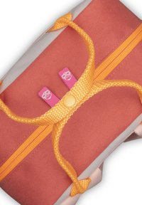 Cipzáras táska korall és szürke anyagból, narancssárga kiegészítőkkel és csomózárással. Két rózsaszín címke fehér grafikával van rajta.