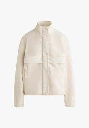 Cremfarbener Fleece-Jacke mit hohem Kragen, Druckknöpfen und einem horizontalen Band über der Brust. Verfügt über zwei Fronttaschen.