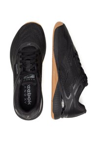 Čierne športové topánky s hornou časťou z sieťoviny, textúrovanými akcentmi a gumovou podrážkou; obsahujú šnúrky a logo na jazyku.