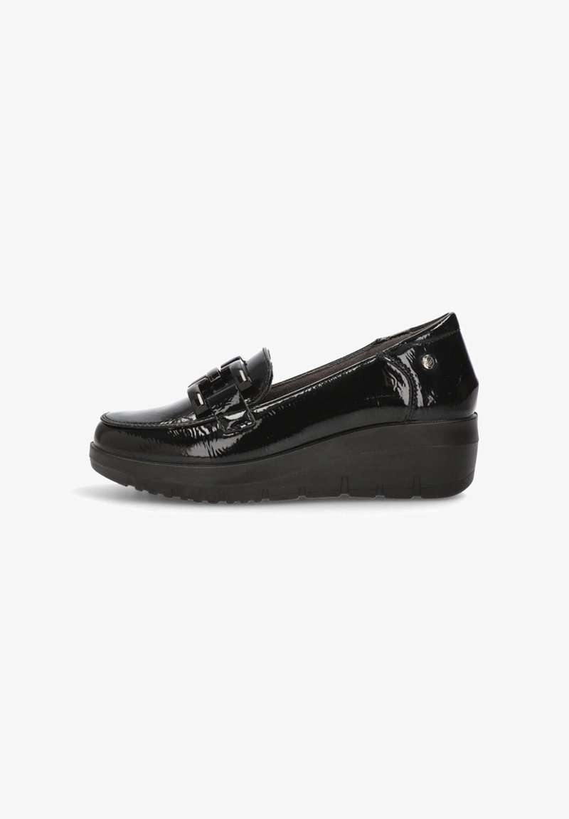 Zapatos de charol negros con punta redondeada, un acento de hebilla en la parte delantera y una suela de cuña gruesa para añadir altura.