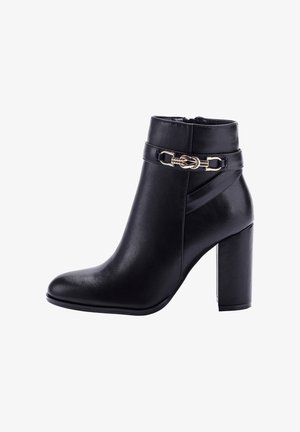 Zwarte enkellaars van soepel leer met een spitse neus, blokhak en een decoratieve gouden hardware accent aan de zijkant.