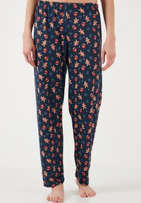 Pantaloni de pijama negri cu o talie elastică, având un model cu oameni de turta dulce, ornamente și fulgi de zăpadă în culori calde.