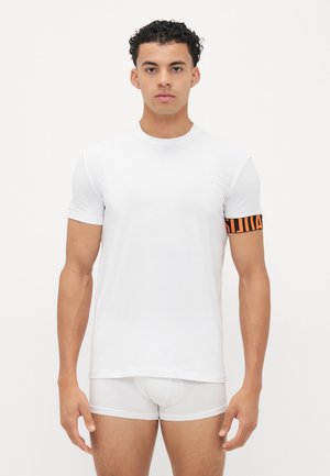 White short-sleeve t-shirt with a round neckline and a black and orange striped armband detail on the left sleeve. Smooth texture.
