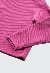 Różowy sweter o żebrowanym splocie z okrągłym dekoltem i długimi rękawami. Miękka tekstura, dopasowane mankiety oraz subtelne detale szwów.