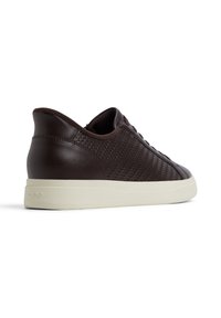 Ruskean nahkaiset sneakerit, joissa on kudottu pinta sivuilla, sileä takapinta ja valkoinen kumipohja. Minimalistinen muotoilu, jossa on sävyyn sopivaa ommelta ja nauhoja.