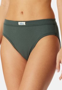 Grüner, gerippter Bikini-Slip mit einem weichen Bund und einem kleinen Logosticker auf der Vorderseite. Der Stoff hat eine glatte Textur.
