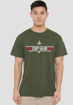 Olive green cotton T-shirt featuring a distressed "TOP GUN" graphic with a jet and red stripes. Short sleeves and a crew neckline.