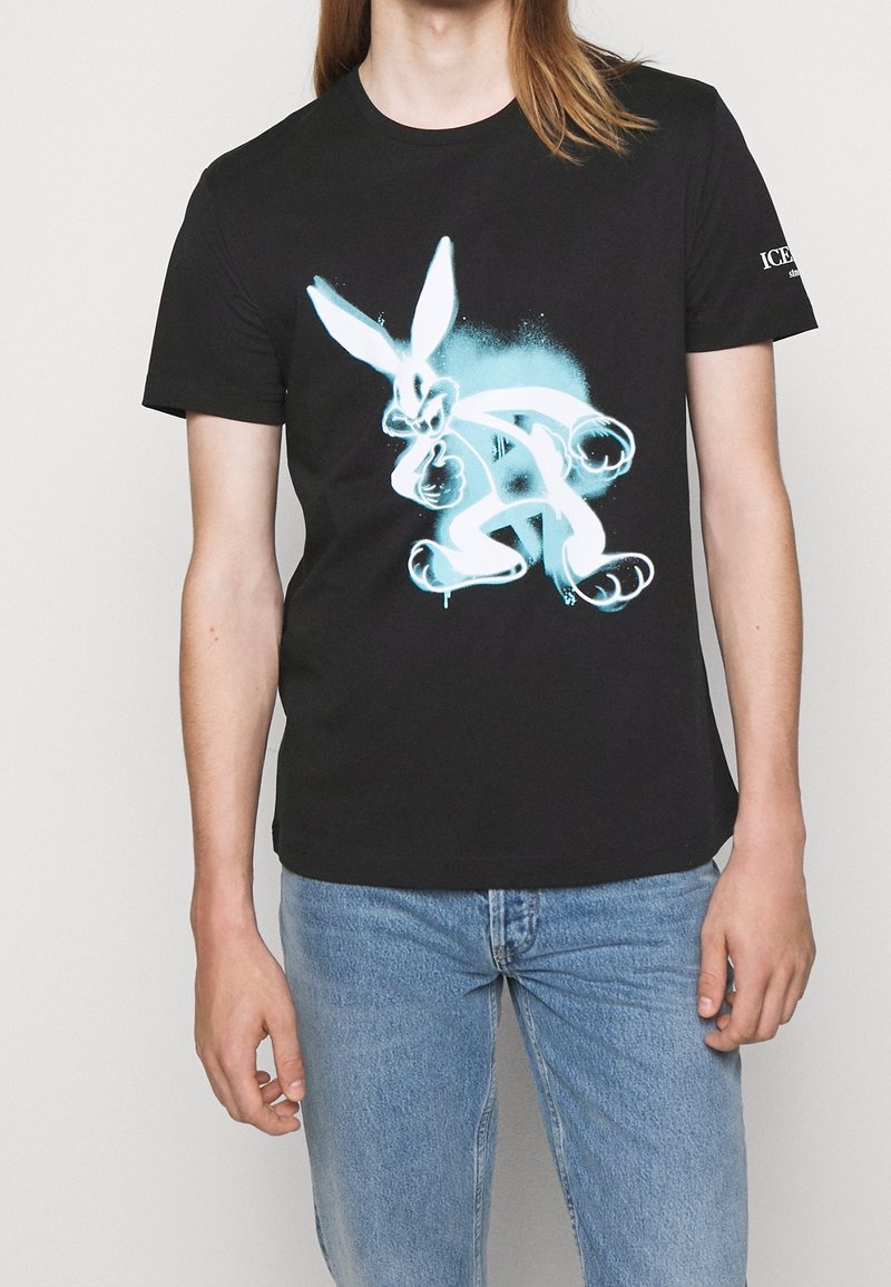 Sort t-shirt lavet af bomuld, med et stort, livligt lyseblå grafisk design af en tegneserierotte på forsiden. Enkel crew neck stil.