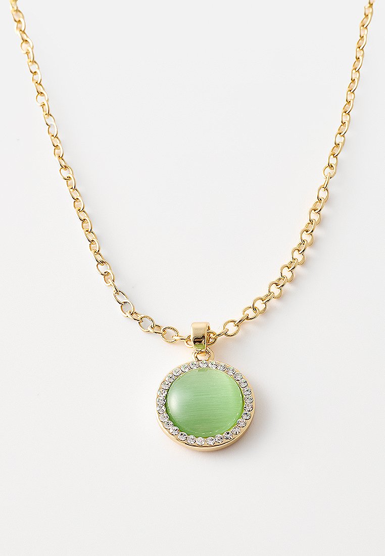 Collar de cadena de oro que presenta un colgante circular verde, rodeado de strass, con un acabado liso y pulido.