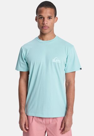 Hellblaues Baumwoll-T-Shirt mit kurzen Ärmeln, rundem Ausschnitt und kleinem weißem Logo auf der linken Brust. Glatte Stoffstruktur.