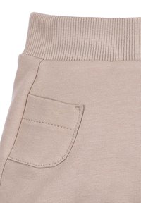 Beige sweatpants met een geribde tailleband en een enkele opgestikte zak aan de zijkant, gemaakt van zachte, geweven stof met een gladde textuur.