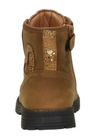 Bruine suède enkelboot met een gestructureerde gouden accent en hartdetail. Voorzien van een zwarte rubberen zool en een gepolsterde kraag voor comfort.