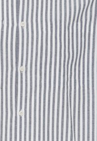 Camicia a maniche lunghe a righe con strisce bianche e blu navy sottili, la trama del tessuto appare liscia, con cinque bottoni lungo la parte anteriore.